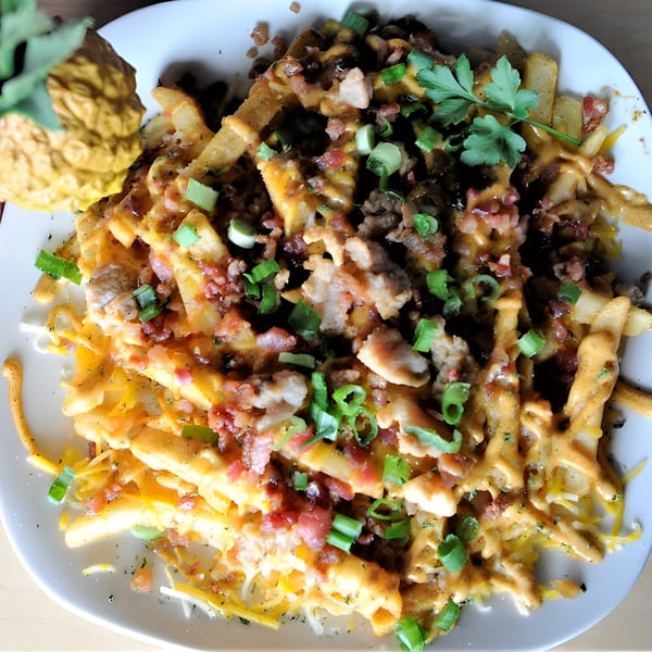Catfish Willy's loaded fries topped with cheese, bacon, green onions, and parsley.
