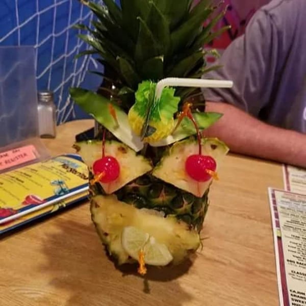 A pineapple drink with cherries and a lime slice, served at Catfish Willy's.