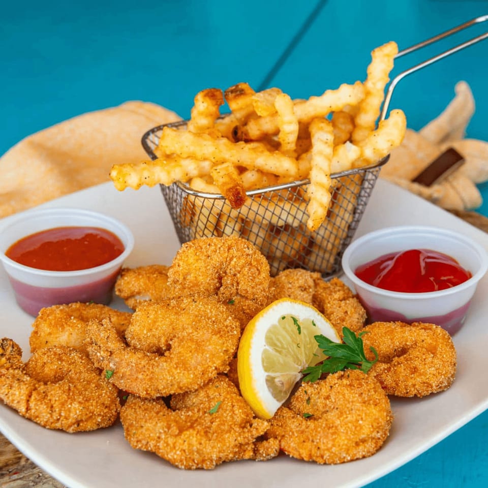 Catfish Willy's fried shrimp and crinkle-cut fries with lemon, parsley, and two dipping sauces.